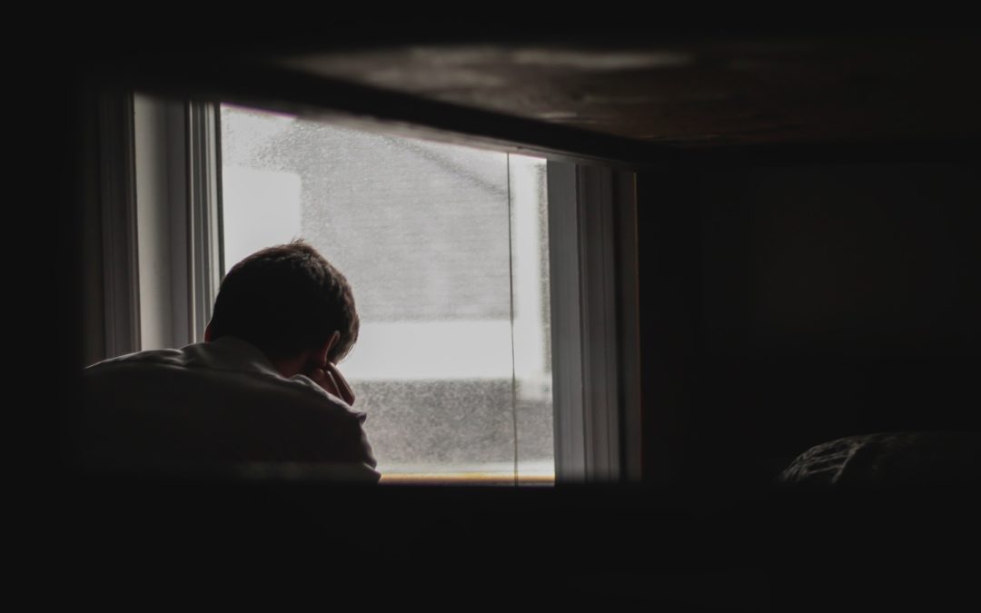 man sitting in front of window